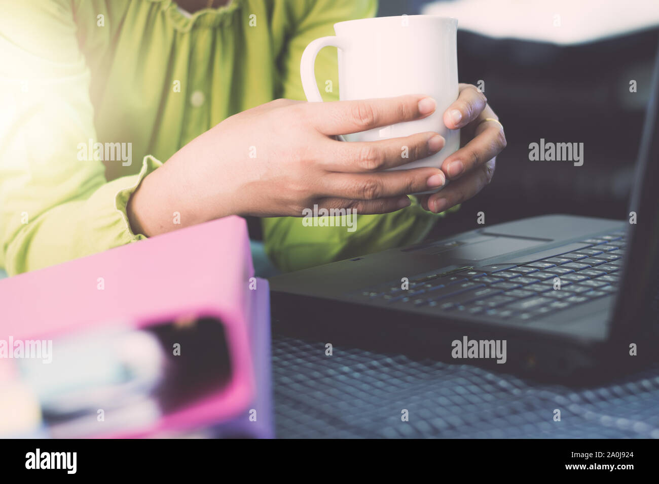 Hände von geschäftsfrau in legerer Kleidung holding Kaffee Tasse während der Planung für die Online-bestellung mit Laptop über das Internet. Geschäftliche und Finanzielle Conc Stockfoto