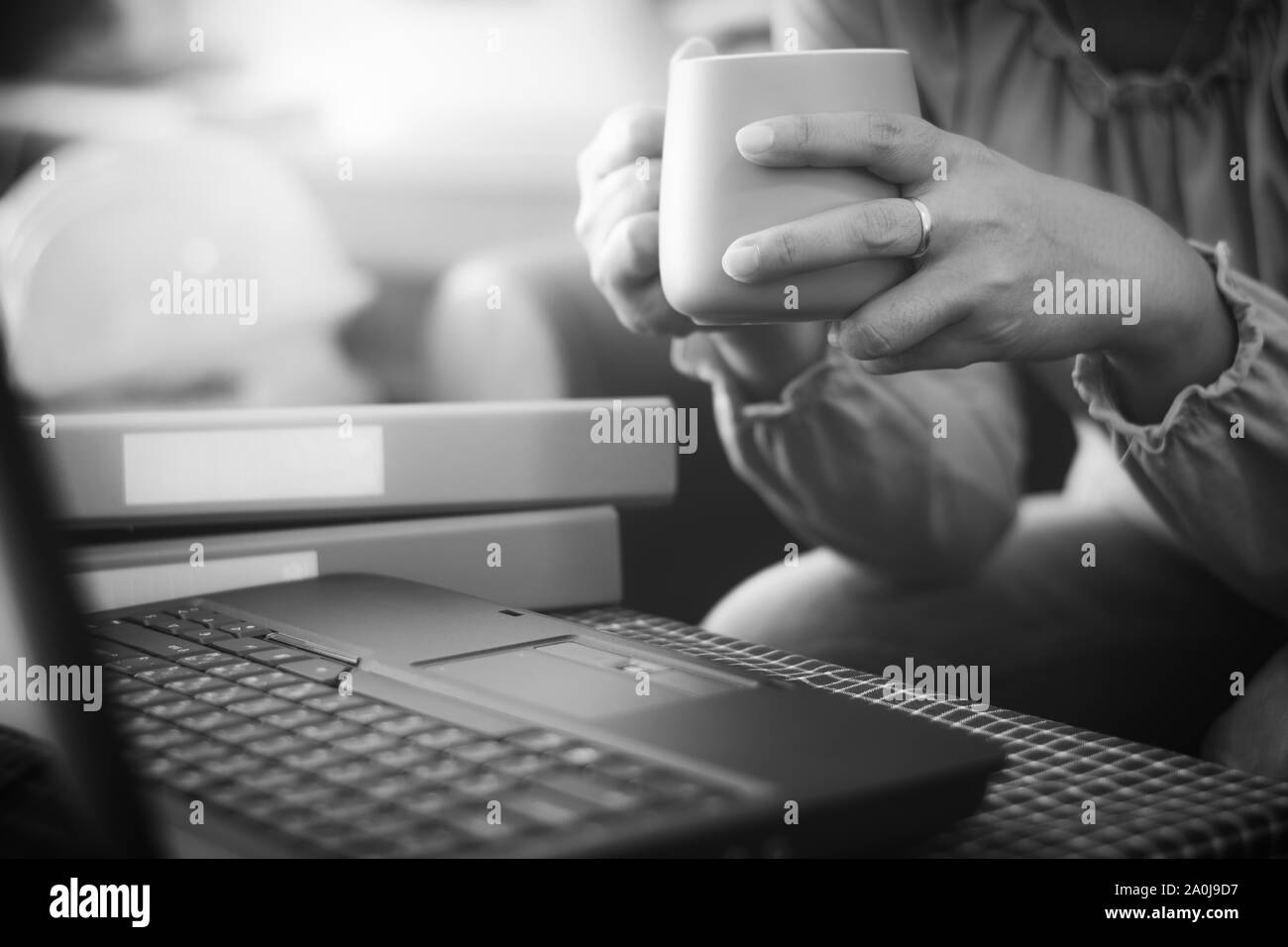 In legerer Kleidung holding Kaffee Tasse während der Planung für die Online-bestellung mit Laptop über das Internet Geschäftsfrau. Geschäftliche und Finanzielle Konzept. Stockfoto