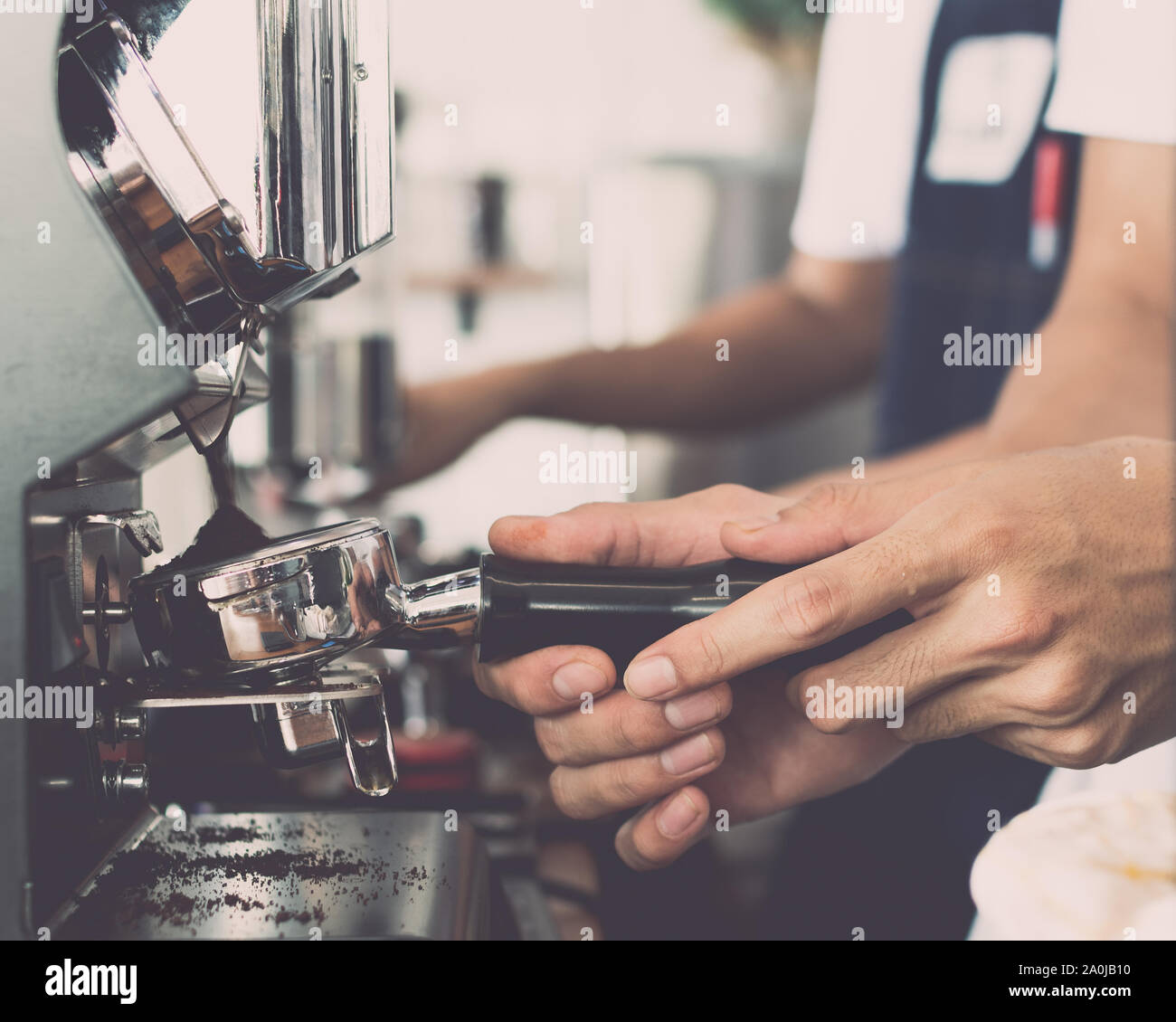 Mann barista mit Kaffeemaschine für die Zubereitung von Kaffee im Cafe, Vintage Farbton. Stockfoto