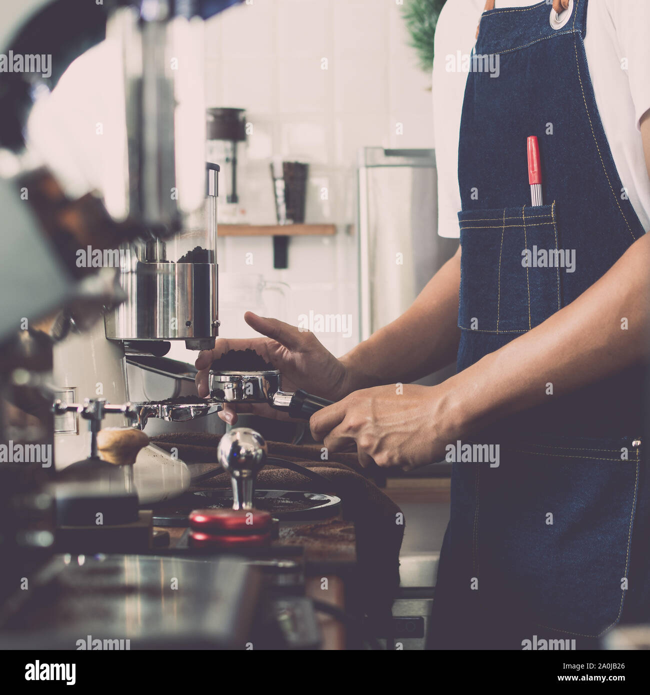 Mann barista mit Kaffeemaschine für die Zubereitung von Kaffee im Cafe, Vintage Farbton. Stockfoto