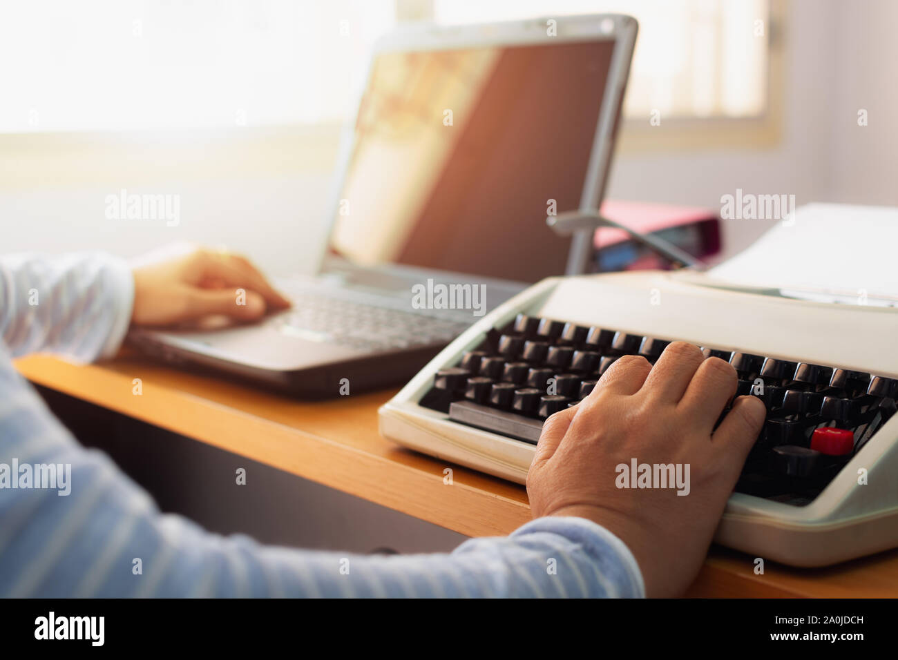 Hände von Frau Eingabe sowohl Schreibmaschine und Laptop auf dem Schreibtisch im Büro. Bildung Konzept. Stockfoto