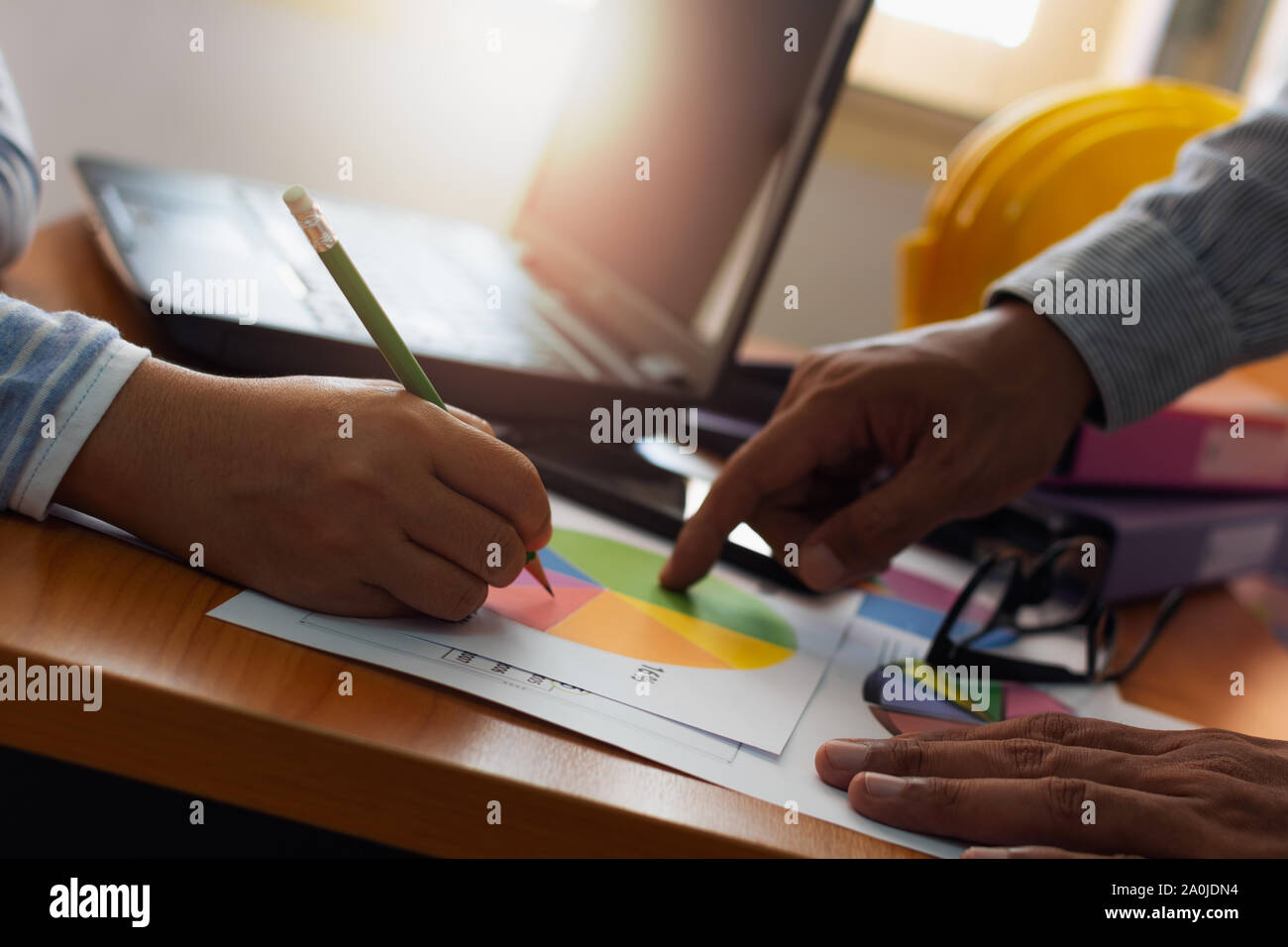 Zwei Kollegen diskutieren und zusammen mit Trade Data Chart Dokument auf Büro Schreibtisch. Business und Office Life Konzept. Stockfoto