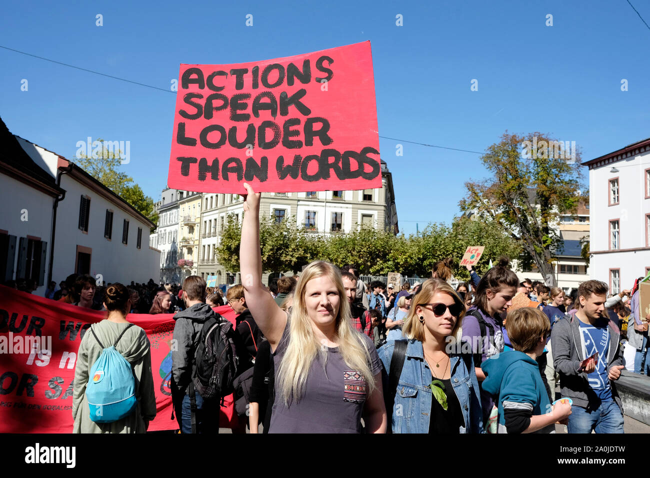 Eine junge Frau hält Aktionen ein Plakat lesen' sagen mehr als tausend Worte' auf das globale Klima. Basel, Schweiz Stockfoto