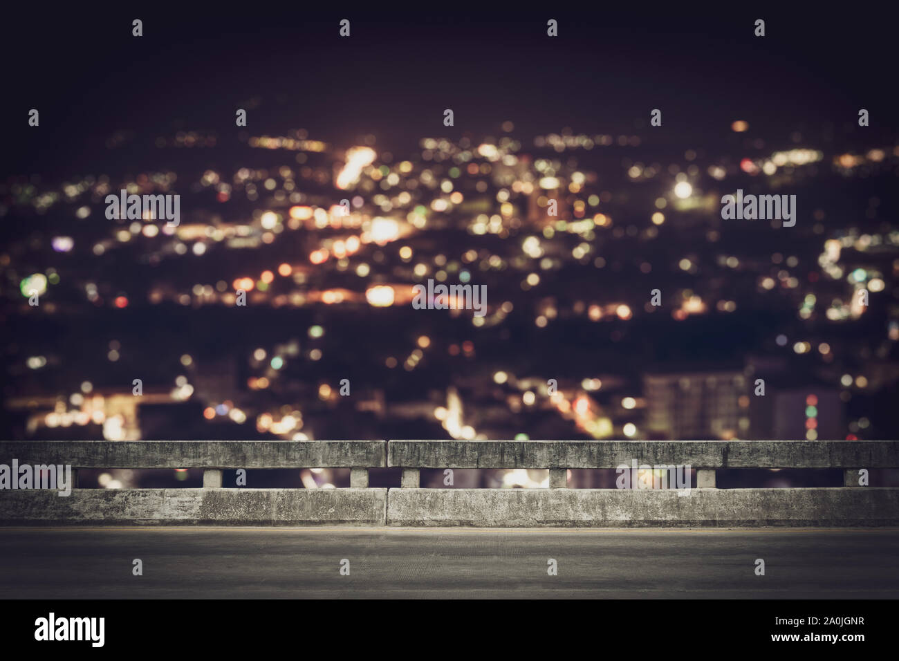Blick vom leeren konkrete Brücke oberhalb der Stadt in der Nacht mit bunten Bokeh. Stockfoto