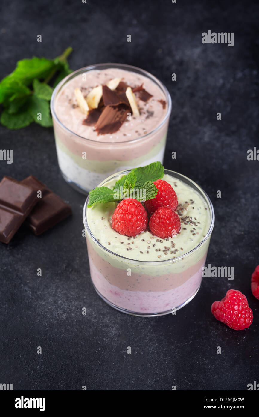 Chia Samen Pudding mit drei Aromen, Kakao, Matcha und Erdbeeren mit Joghurt, Schokolade und Minze. Nahaufnahme Stockfoto