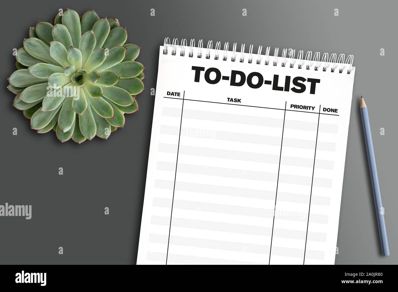 Blick von oben auf die Spirale Notebook mit Aufgabenliste auf grauen Schreibtisch mit sukkulenten Pflanzen- und Bleistift Stockfoto