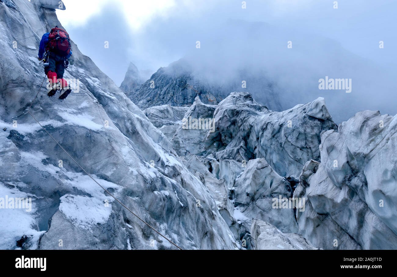 Kletterer klettern das Eis Wand während das schlechte Wetter. Stockfoto