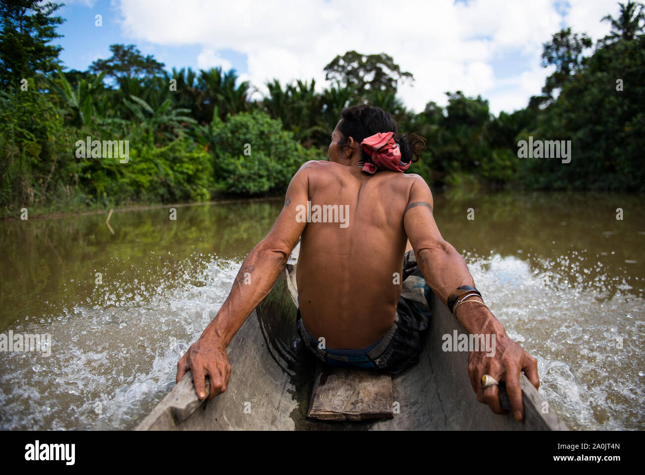 Mentawai Stamm Mann im Kanu sitzend beobachten die Landschaft Stockfoto