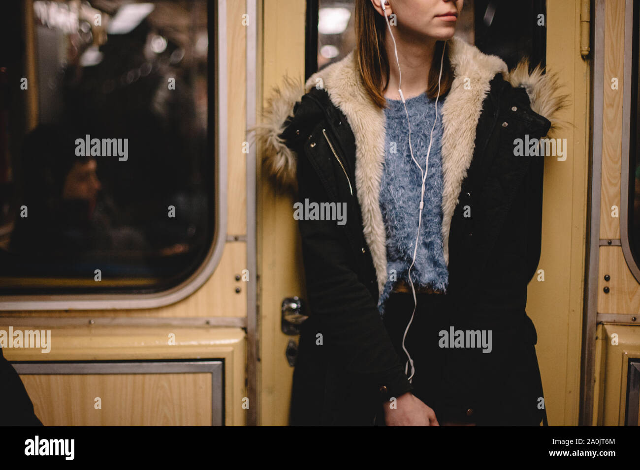 Frau Musik hören über Kopfhörer unterwegs in der U-Bahn Stockfoto