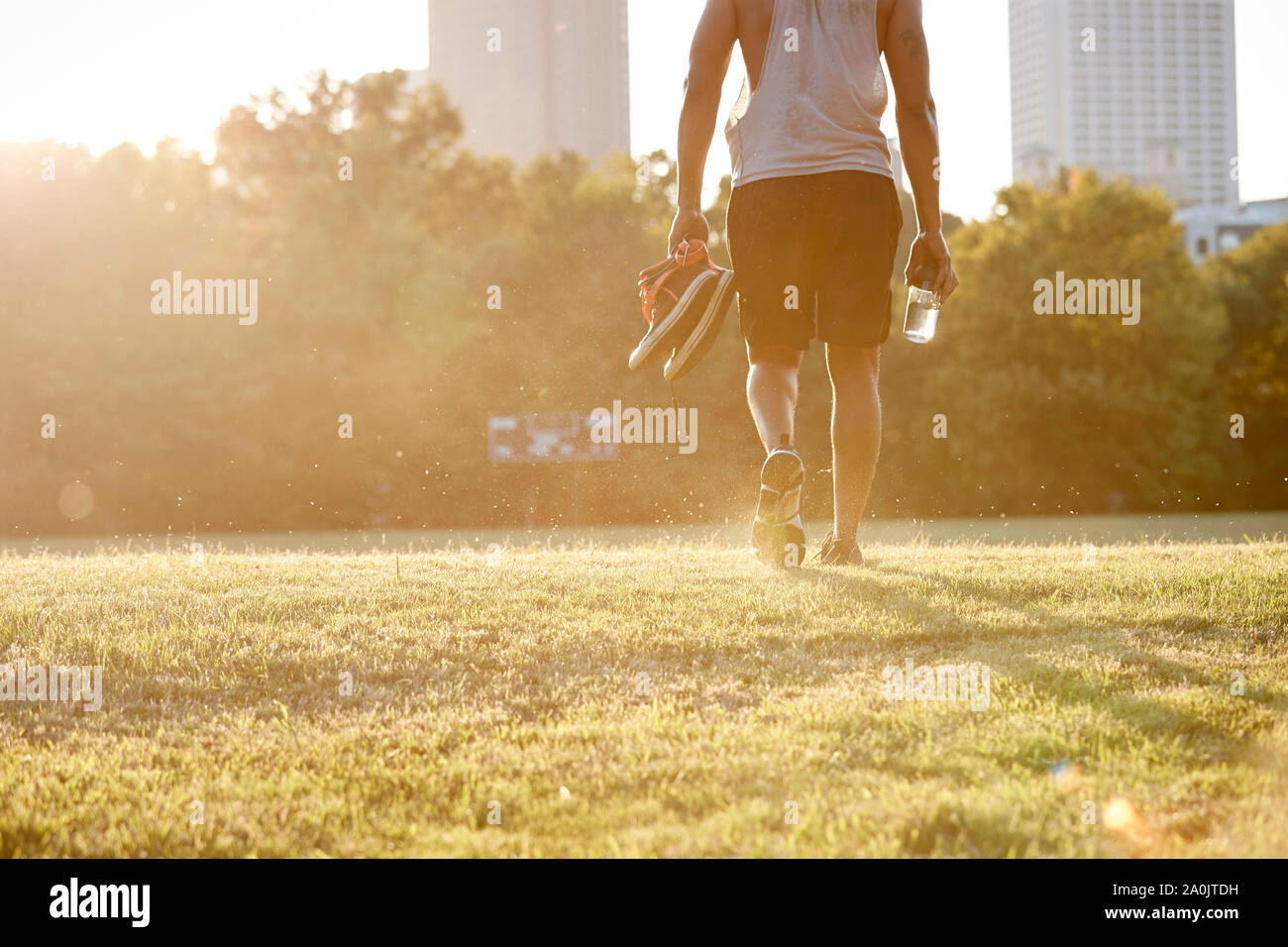 Afro man walking über Feld in städtischen Park Stockfoto
