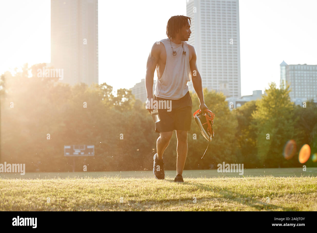 Afro man walking über Feld in städtischen Park Stockfoto