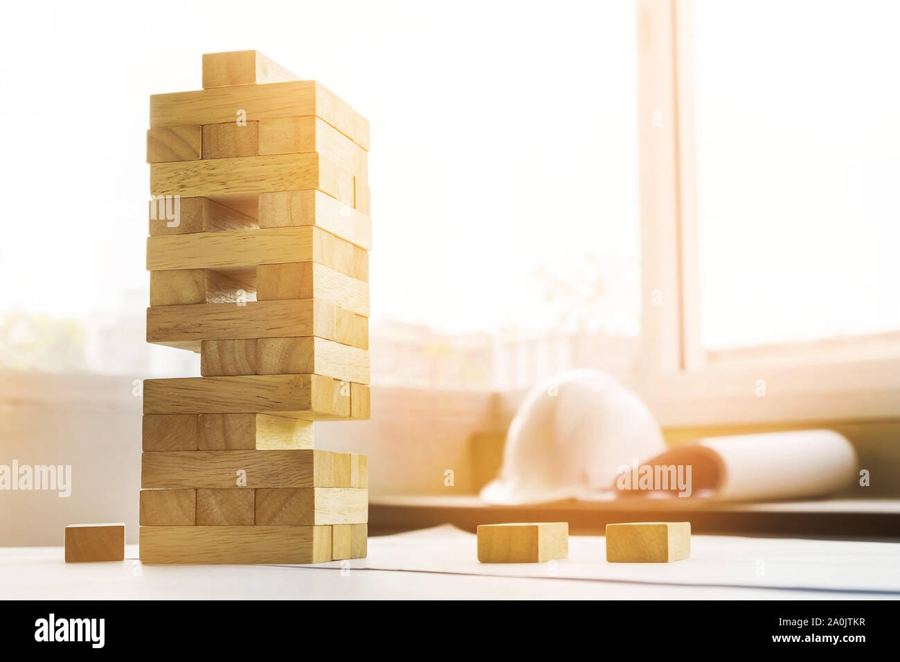die Blöcke Holz tower Spiel mit architektonischen Ingenieur Pläne oder Blaupausen Kompasse, Stifte und Lineal auf Holztisch, Plan und Gebäudekonzept. Stockfoto