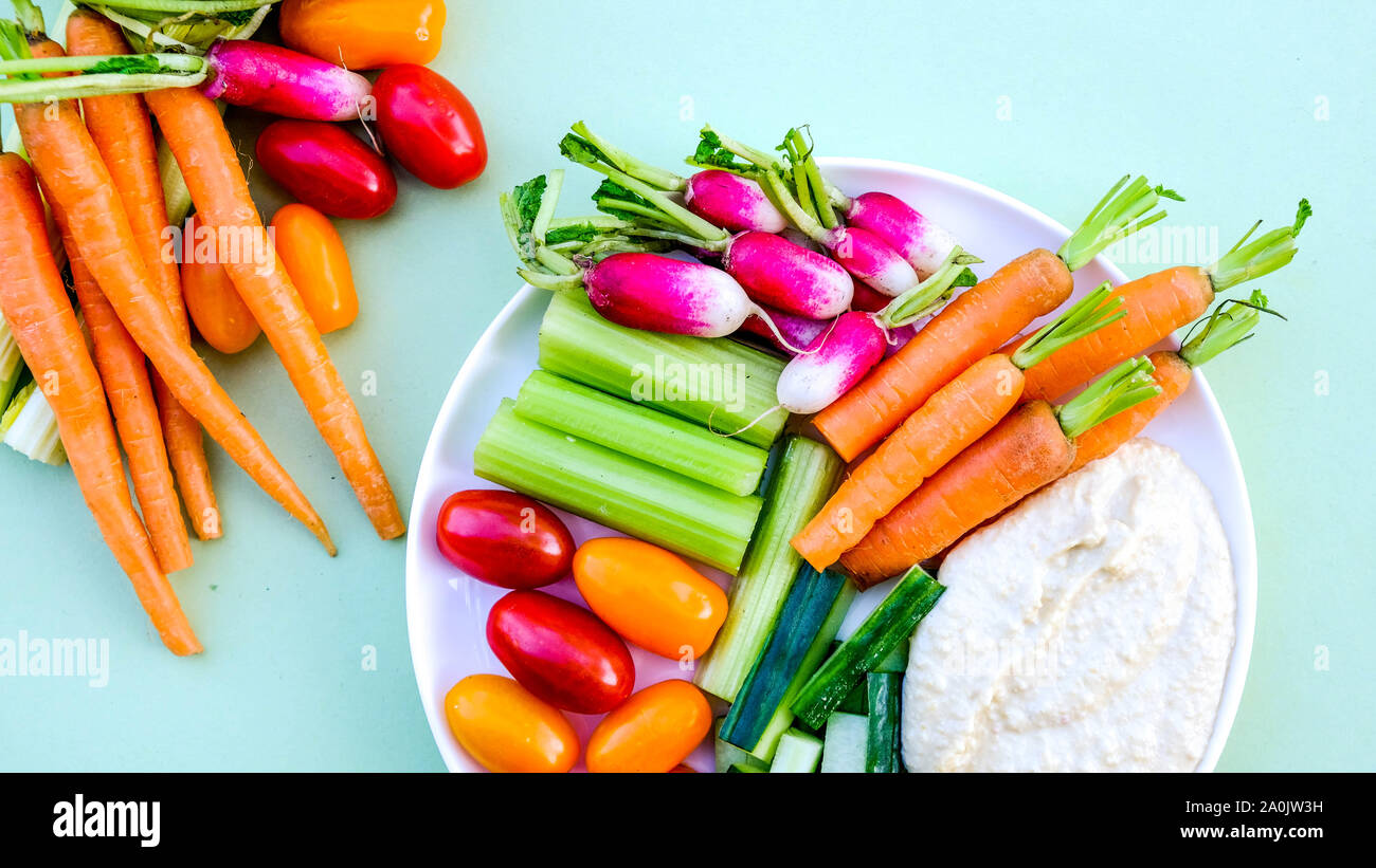 Frisches Gemüse Gemüsestäbchen Platte mit Hummus und Karotten, Radieschen, Gurken, Sellerie und Tomaten/Paradeiser Stockfoto