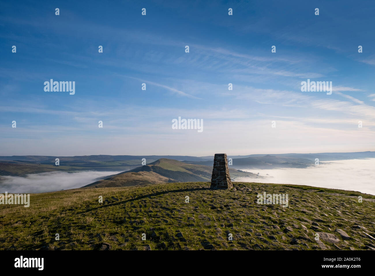 Trig point auf Mam Tor, Peak District, UK. Am frühen Morgen mit Nebel im Edale und Hoffen, Tal, und die Großen Bergkamm, der über dem Nebel Stockfoto