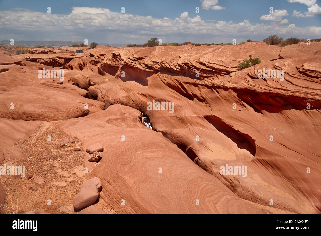 Eine touristische verschwindet in einer Felsspalte in den roten Felsen am Lower Antelope Canyon an einem Sommertag, der Website, wo 11 Touristen während einer Flash gefangen waren Stockfoto