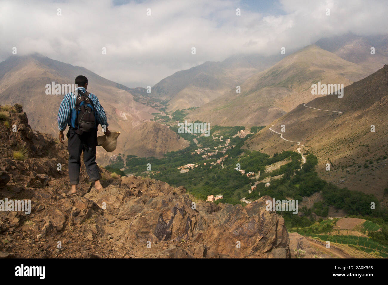 Marokkanischen Mann in den 20er Jahren hält die Ansicht von Tizi'n Tamer, 2200 Meter hoch in Ait Mizane Tal, Hohen Atlas, Marokko, Afrika zu bewundern. Stockfoto