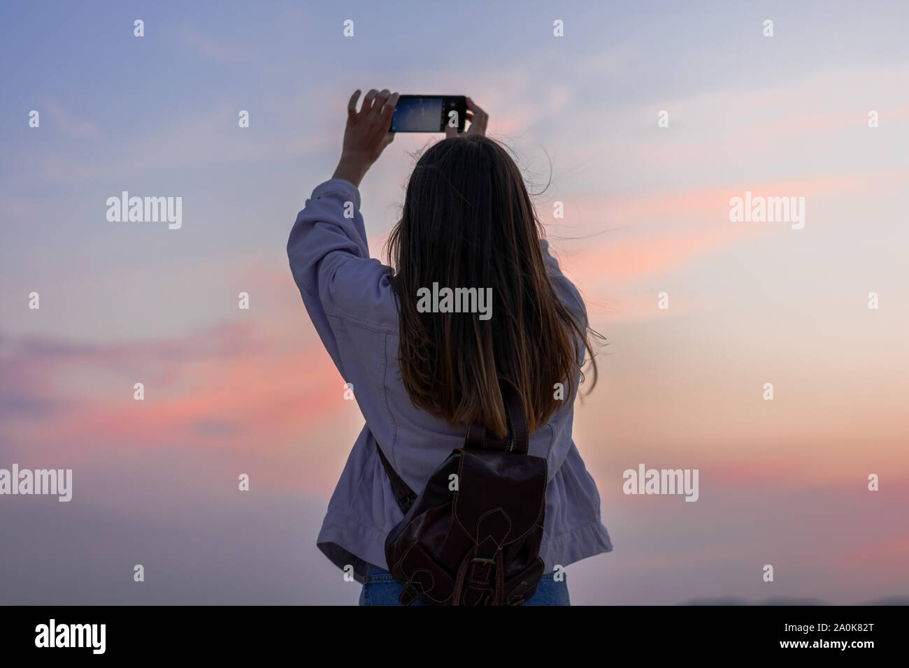 Junge Frau ist ein Bild von den Himmel mit ihrem Smartphone Stockfoto