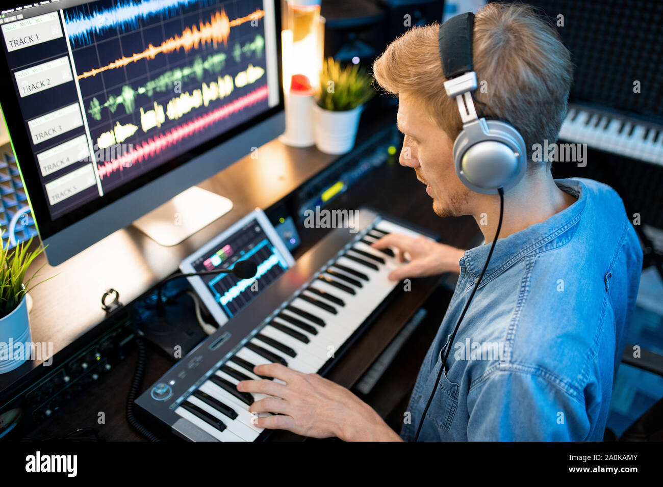 Zeitgenössische Musiker in Kopfhörer Aufnahme neuer Musik und Songs im Studio Stockfoto