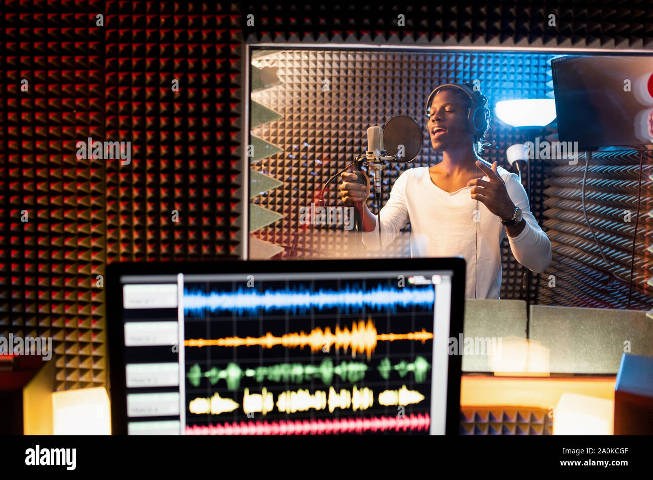 Junger Mann der Afrikanischen Ethnie Singen in das Mikrofon Sound Recording Studio Stockfoto