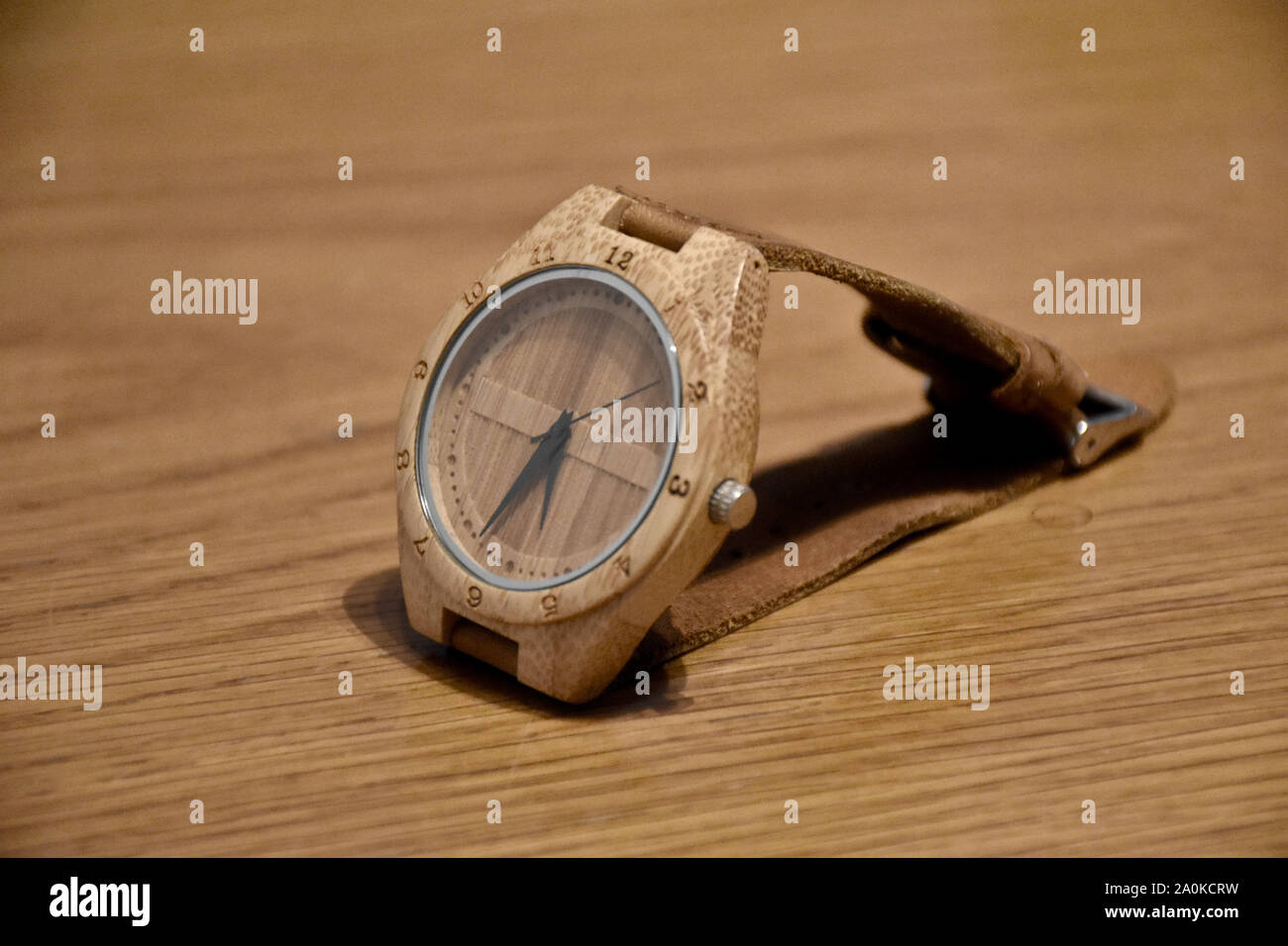 Der umweltfreundliche, Kunststoff- und handgefertigte Bambus Armbanduhr mit Lederband aus Thailand auf einen hölzernen Tisch Stockfoto