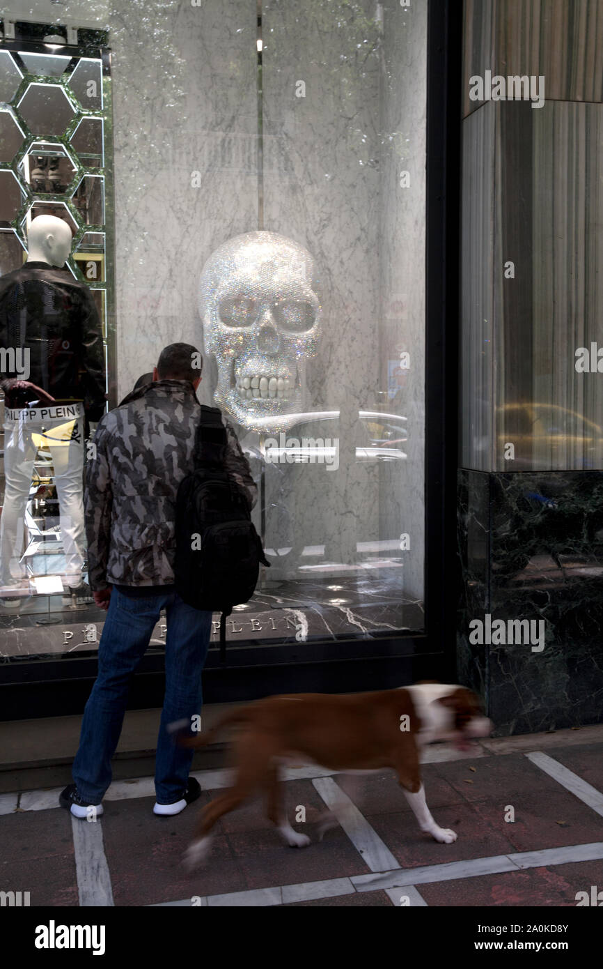 Mensch und Hund suchen im shop Fenster mit Totenkopf stadiou Athen ATTIKA Griechenland Stockfoto