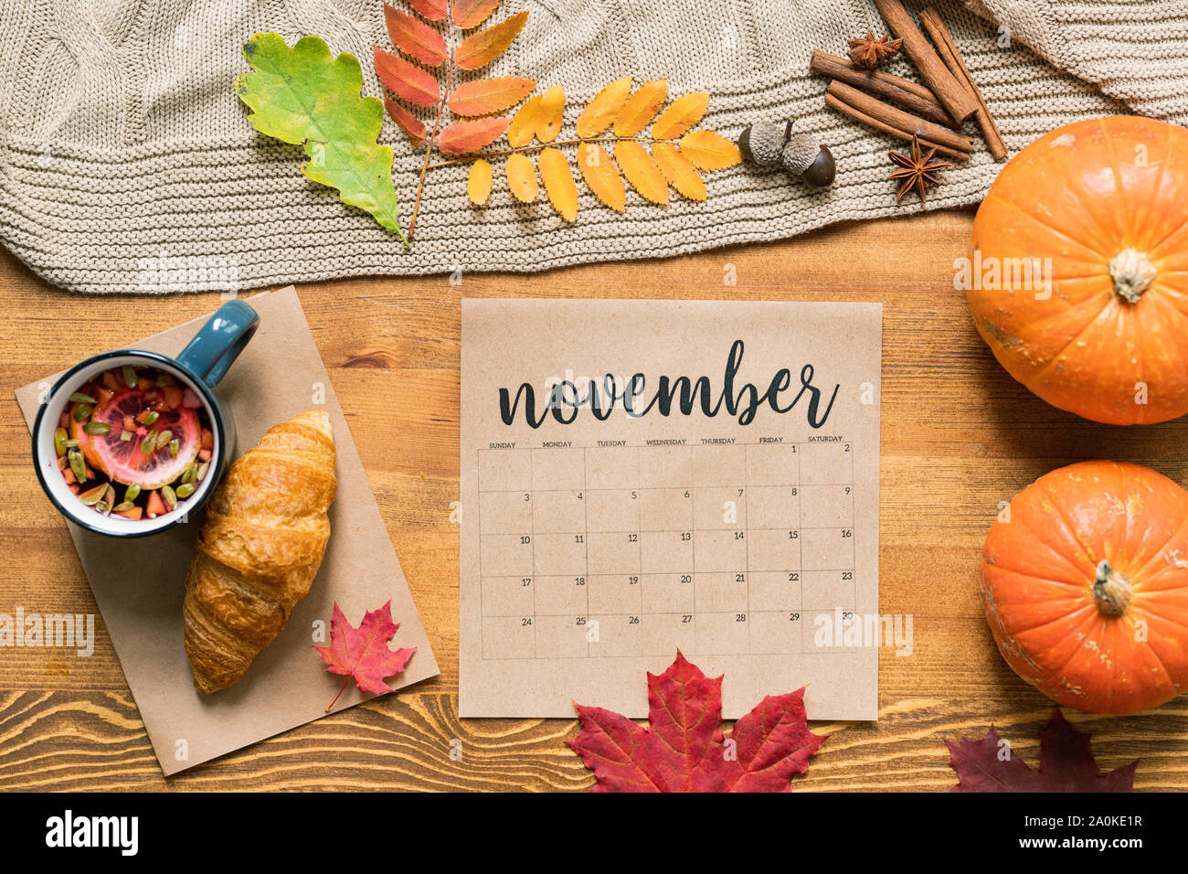November Kalender mit heißen Getränk und ein Croissant, reife Kürbisse, Blätter und Gewürze Stockfoto