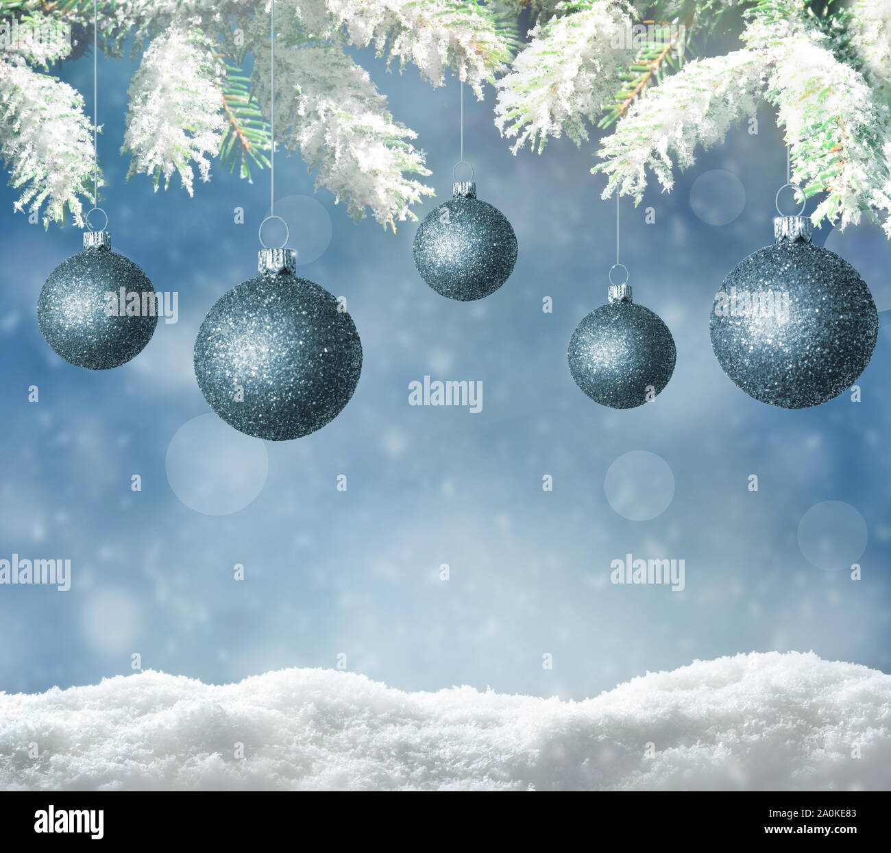Weihnachten Hintergrund. Winter verschneite Tanne Zweig und blauen Himmel als Hintergrund. Christmas Ball. Winter Weihnachten Konzept. Stockfoto