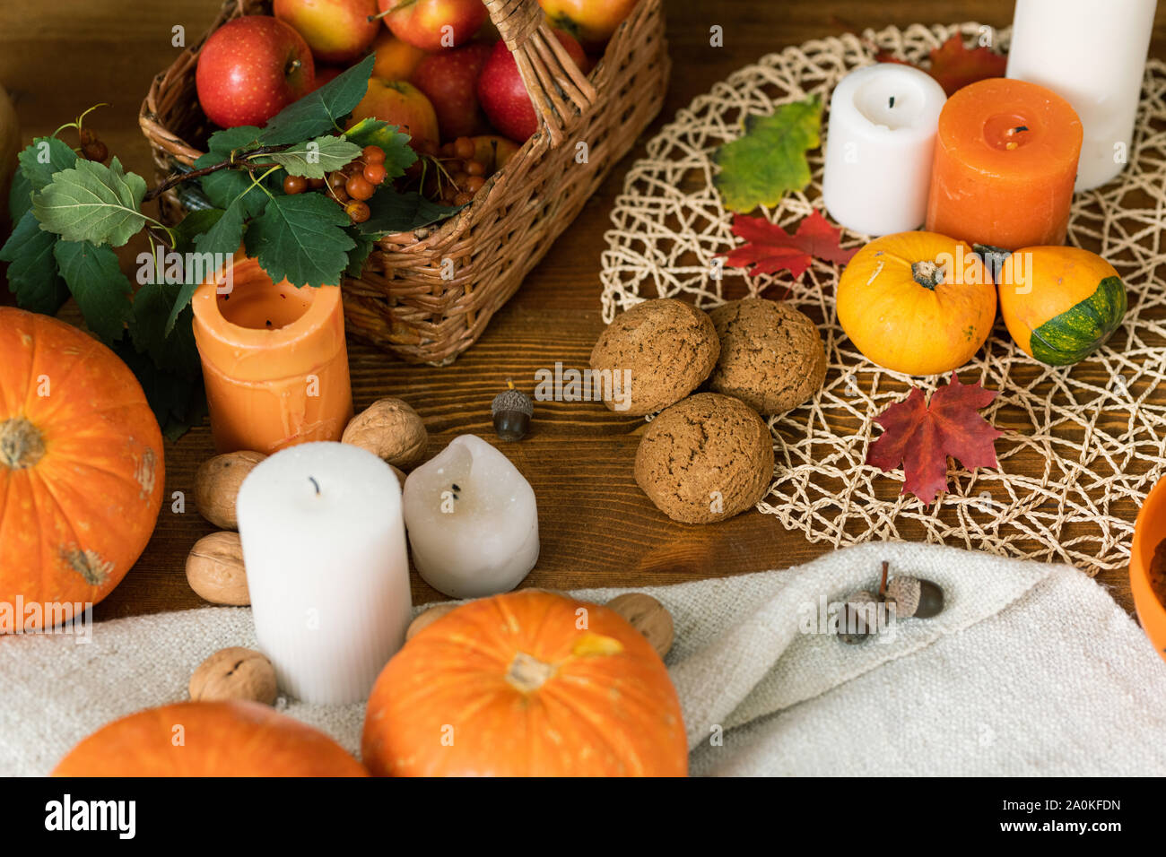 Zusammensetzung der Reife Kürbisse, Kerzen, Kekse, Blätter und korb mit äpfel Stockfoto
