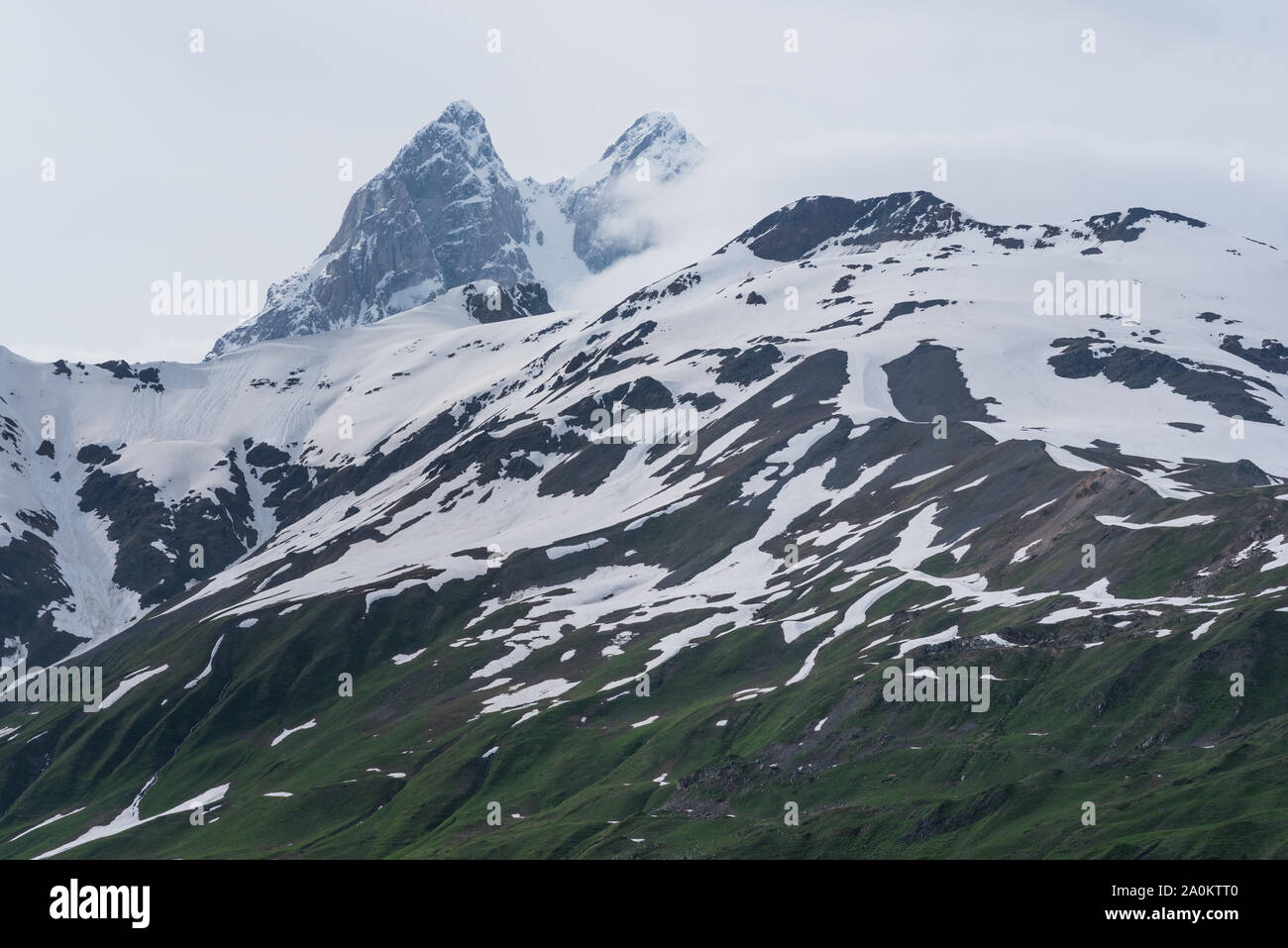 Schneebedeckte Bergmassiv mit zwei Gipfeln hinter, die Oberseiten der Ushba Berg. Auf dem Trek von Mestia zu Mazeri (Becho). Georgien. Im Kaukasus. Stockfoto