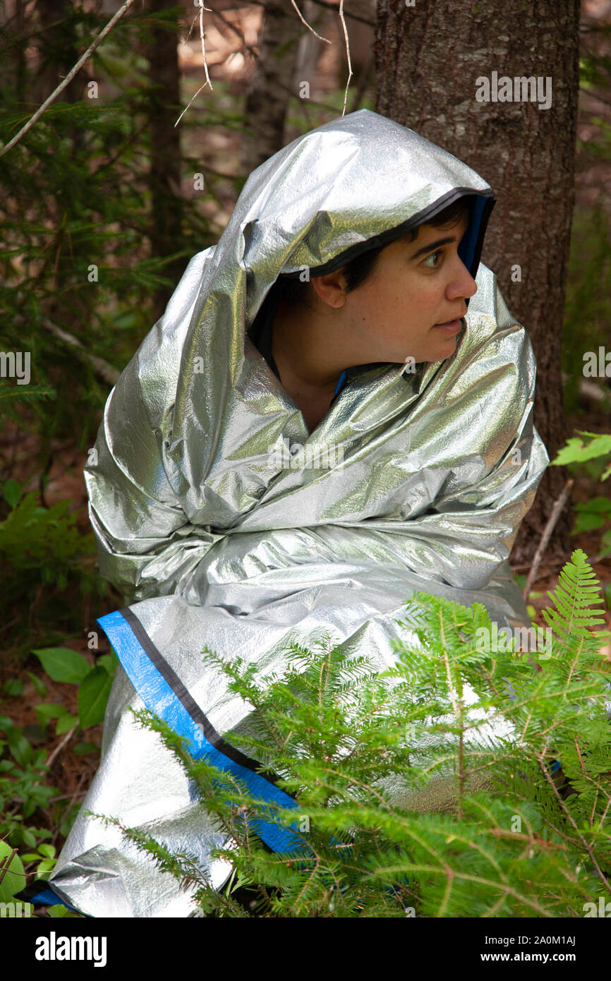 Person schaut sich um, ängstlich, während in den Wäldern tragen eine silberne Decke verloren Stockfoto