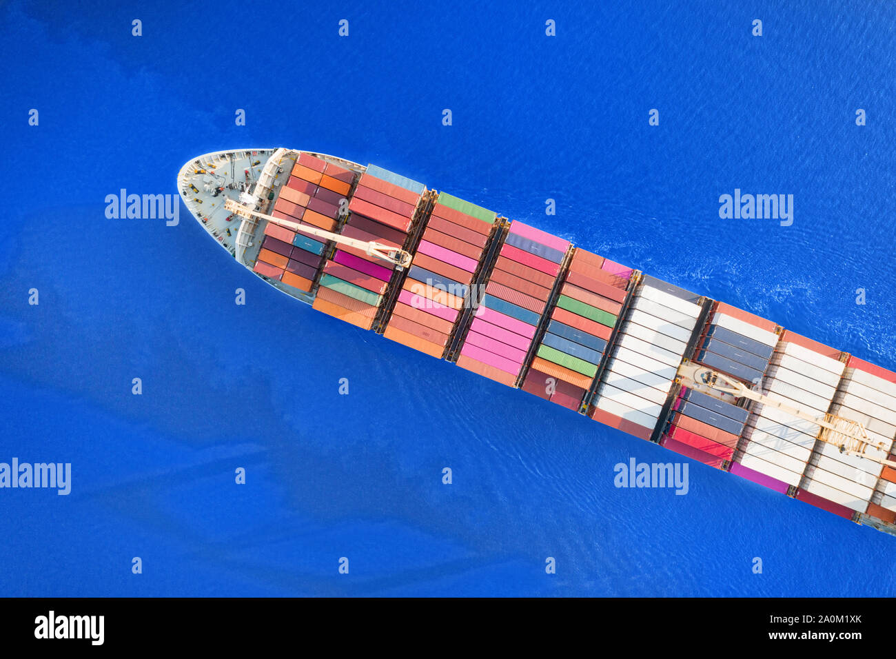 Große voll beladenen Container schiff, das leuchtend blaue Meer. Top Luftbild Stockfoto