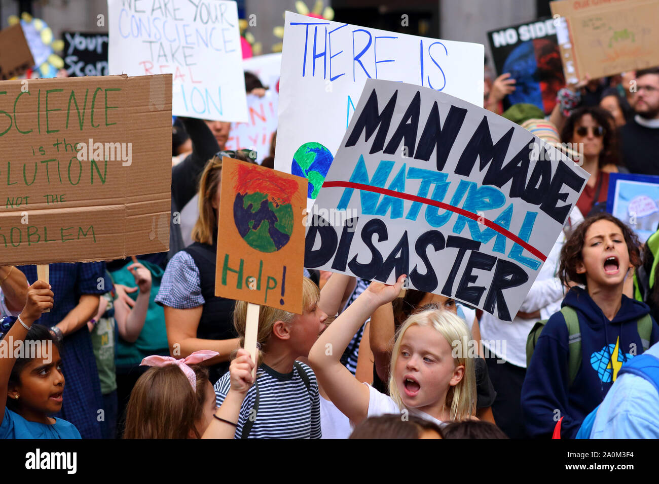 New York, NY, 20. September 2019. Kinder halten Schilder "man Made Disaster" beim von Jugendlichen geführten NYC-Klimabrek. Zehntausende Menschen, Studenten nahmen an der demonstration Teil und versammelten sich am Broadway zum Battery Park mit Greta Thunberg als Teilnehmer und Gast. Stockfoto