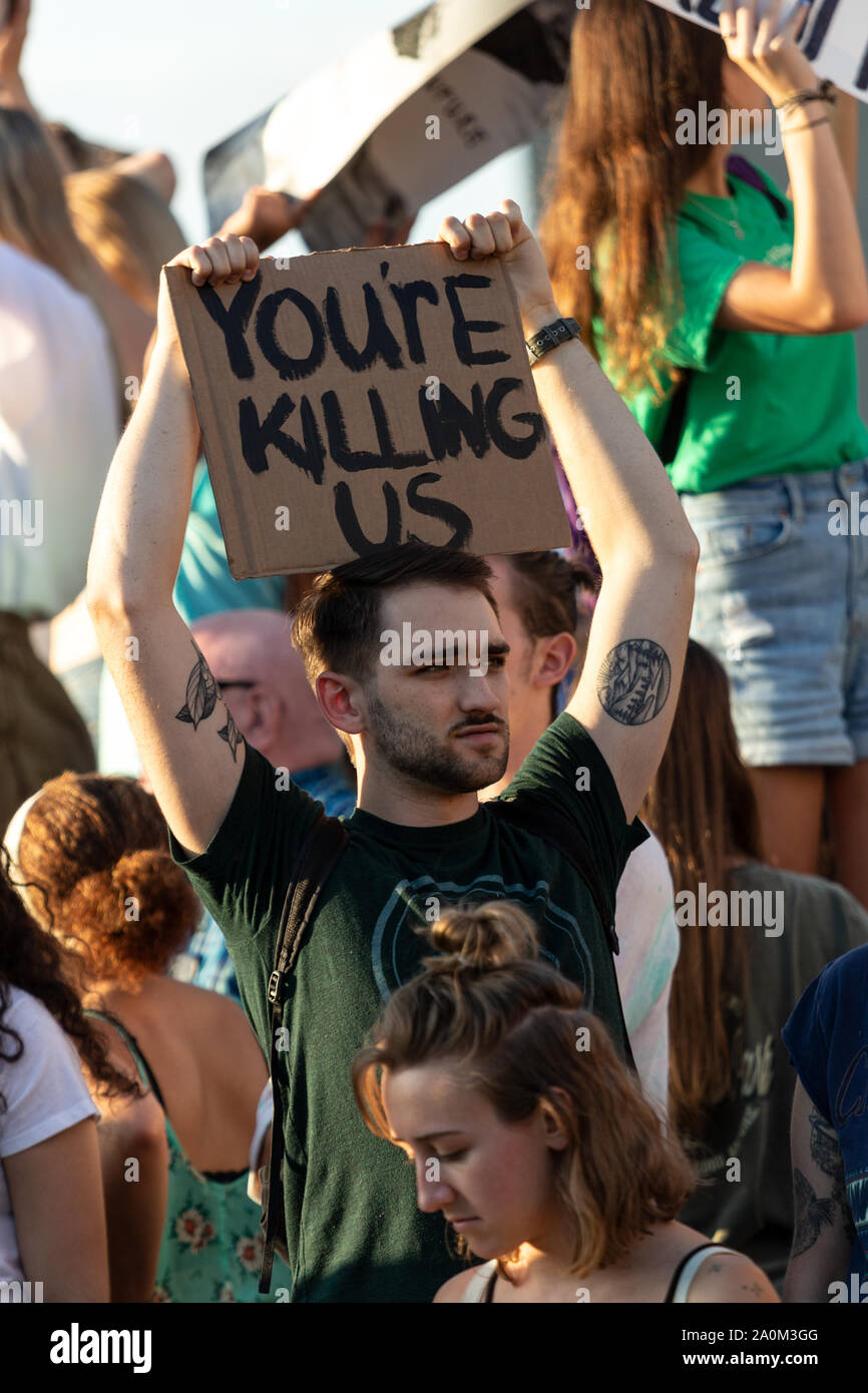 Tausendjährige Demonstranten halten Zeichen bei der Internationalen Klima-Justice-Rallye in Asheville, NC, USA. Stockfoto