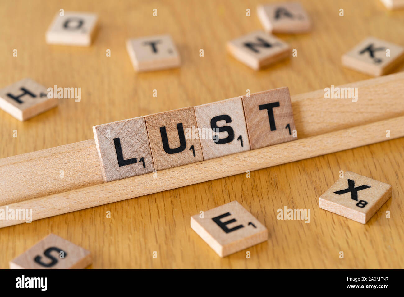 Scrabble Holz Buchstaben auf einem Rack Rechtschreibung das Wort Lust Stockfoto