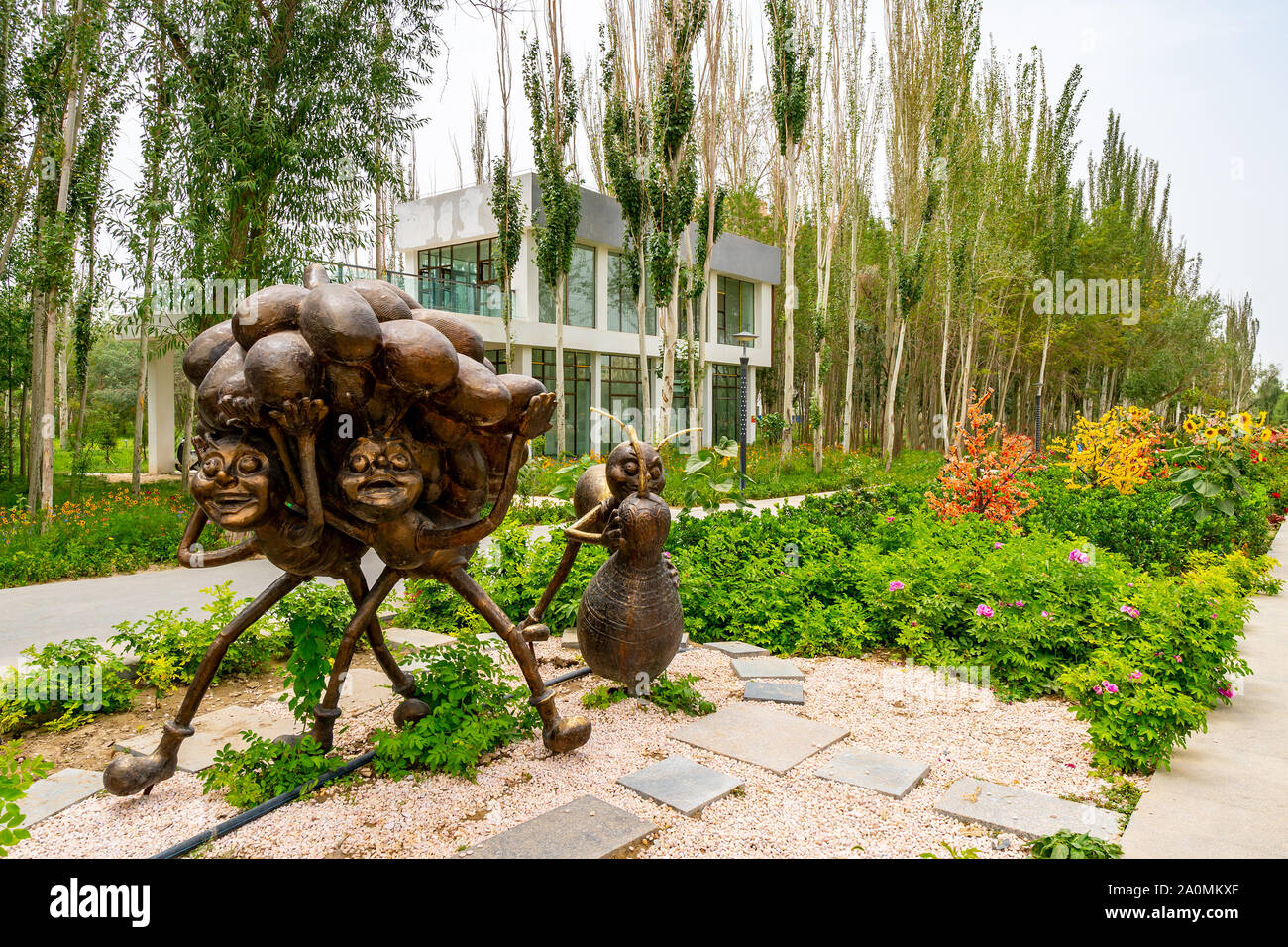 Hotan malerischen Kunlun Lake Park Blick auf Cartoon Ameisen Trauben tragen auf ihren Köpfen Statue an einem bewölkten Himmel Tag Stockfoto