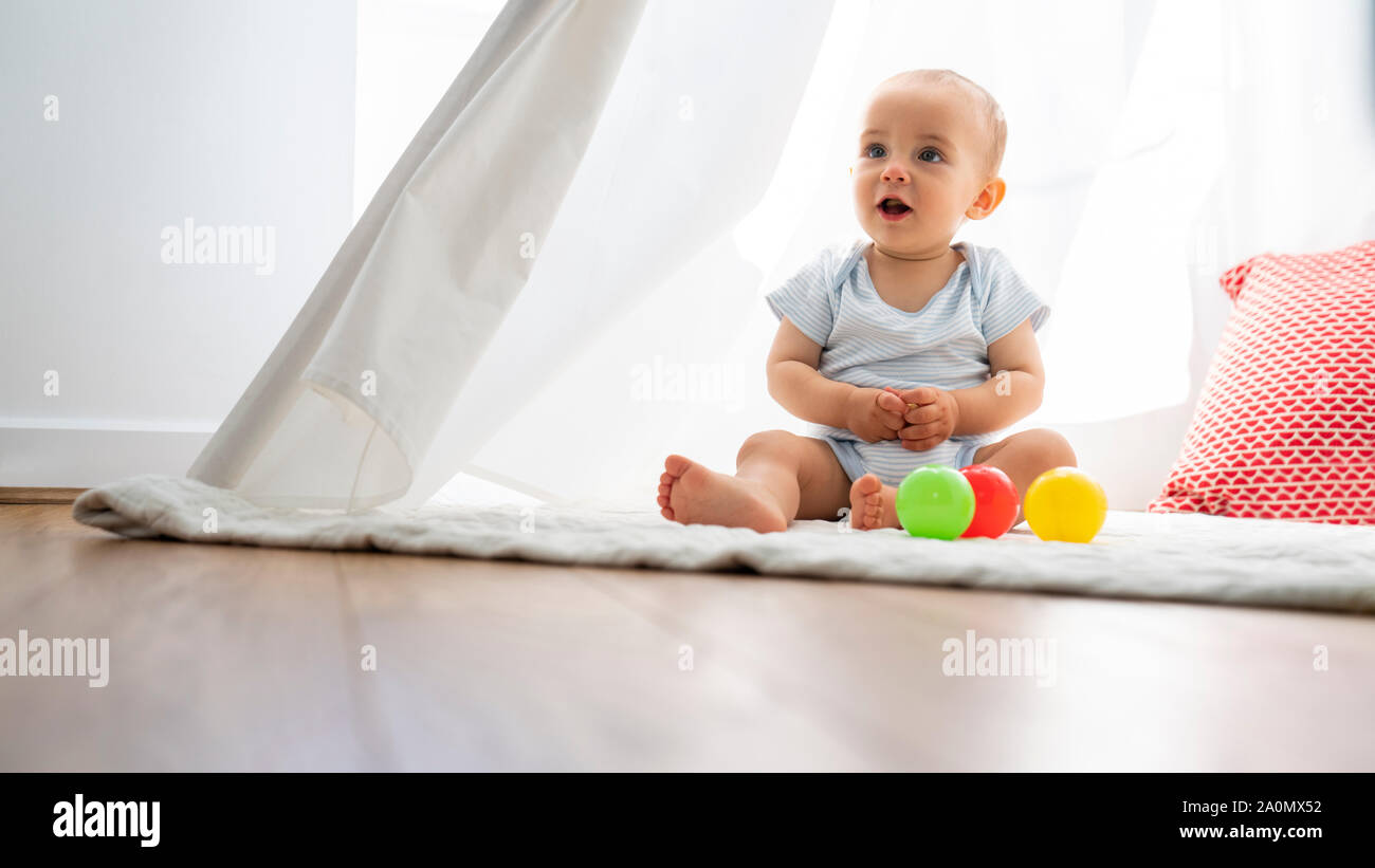 Baby Junge sitzt im Zelt und mit Spielzeug spielen zu Hause Stockfoto