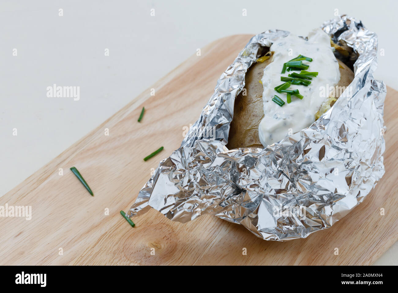 Backofen Ofenkartoffel mit Kräuter Frischkäse auf Holzbrett Stockfoto