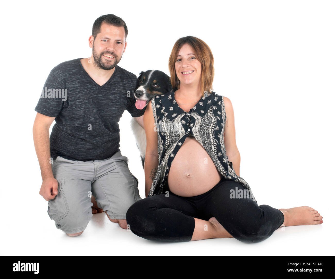 Paar und Hund vor weißem Hintergrund Stockfoto