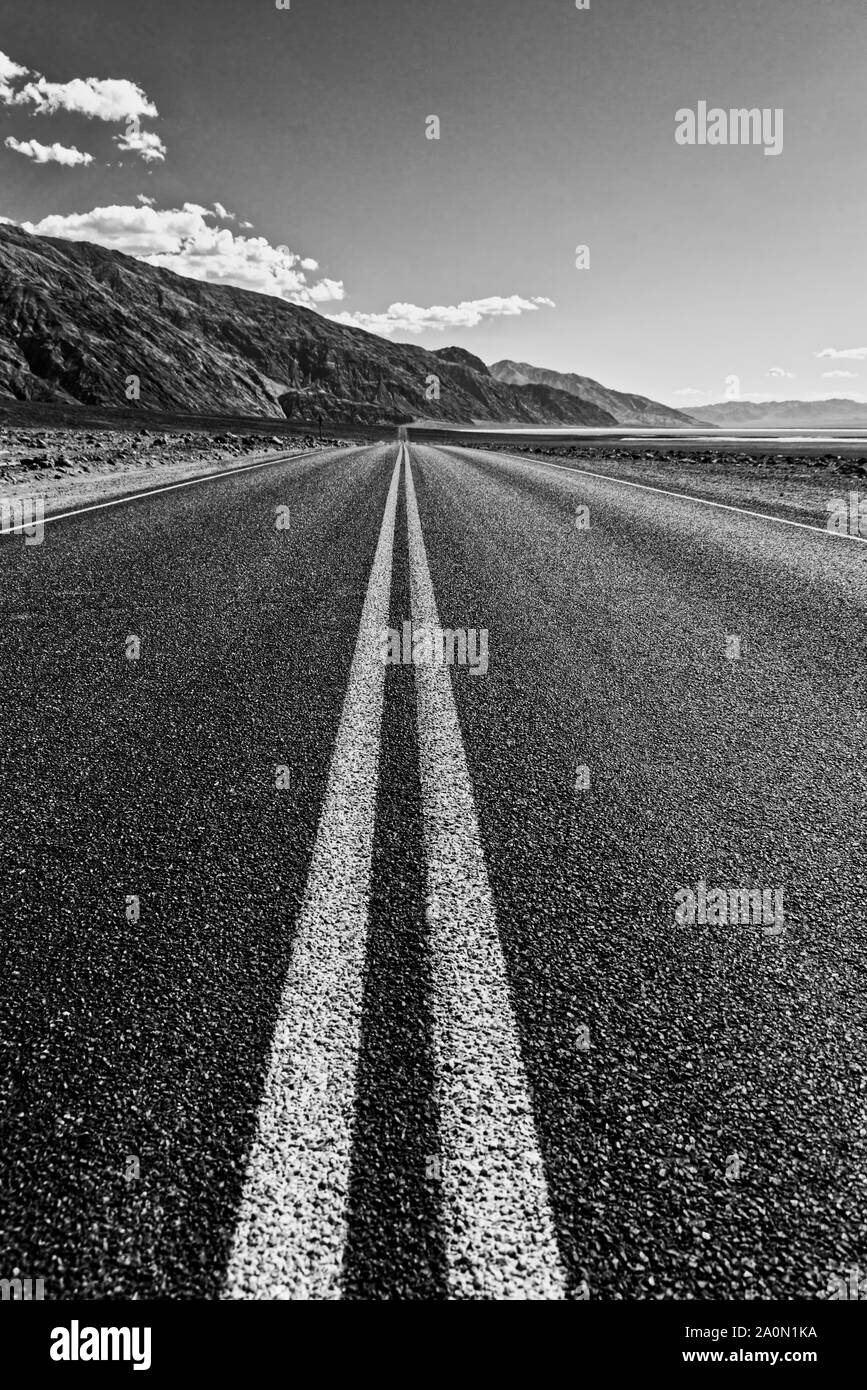 Blick auf eine endlose gerade Straße durch die Wüste in den USA läuft Stockfoto