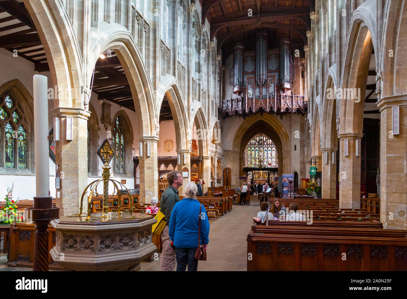 Stratford-upon-Avon, Warwickshire, England. Besucher bewundern Innenraum der Kirche der Heiligen Dreifaltigkeit. William Shakespeare und Anne Hathaway sind in t begraben Stockfoto