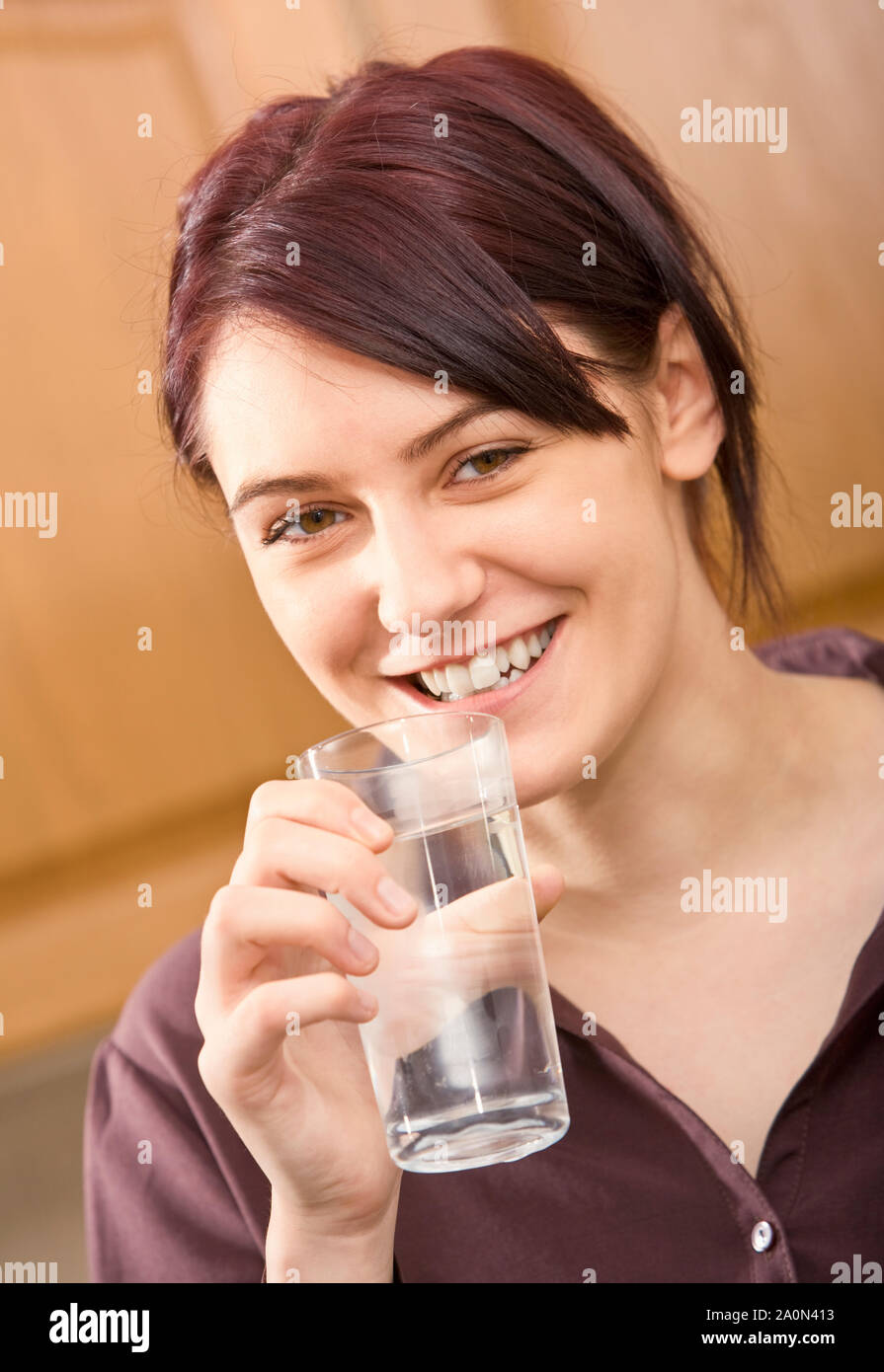 Junge Frau trinkt ein Glas Wasser Stockfoto
