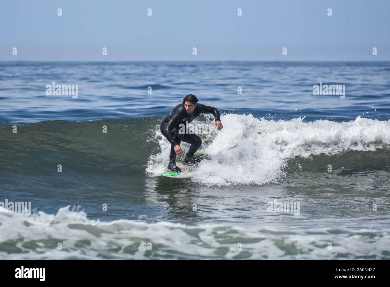 Surfer in einem Neoprenanzug, einem rechten Welle aus einem California Beach. Stockfoto