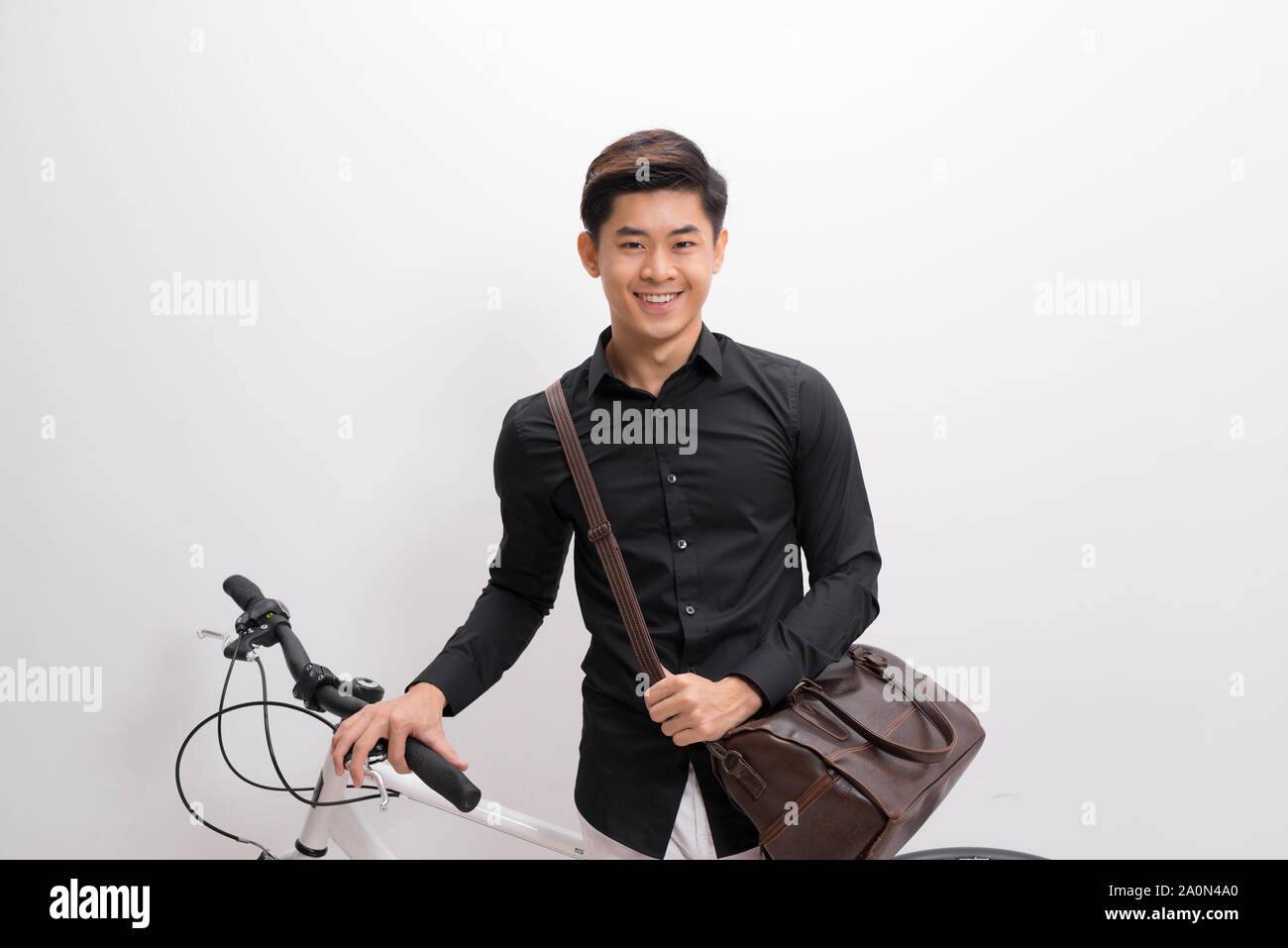 Hübscher junger Mann mit Schulter- und Fahrradverleih stehen auf weißem Hintergrund Stockfoto