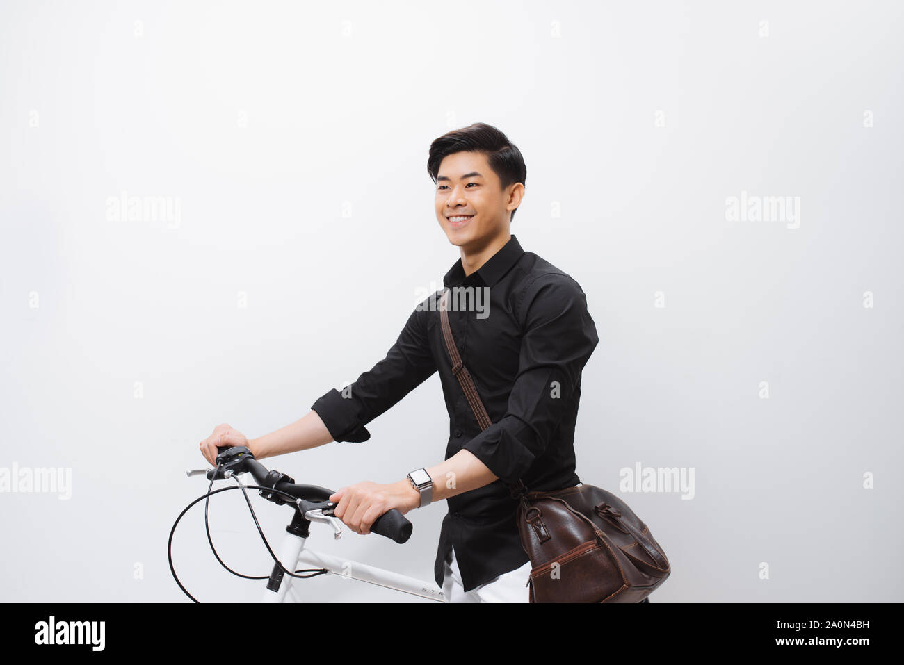 Stilvolle hübscher junger Mann mit Fahrrad weg schauen auf Weiß isoliert Stockfoto
