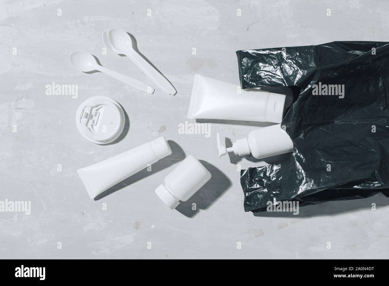 Kein Kunststoff Recycling Konzept Kunststoff weiß Geschirr Teller Tassen auf Stein Löffel. Kopieren Sie Platz. Ansicht von oben Stockfoto