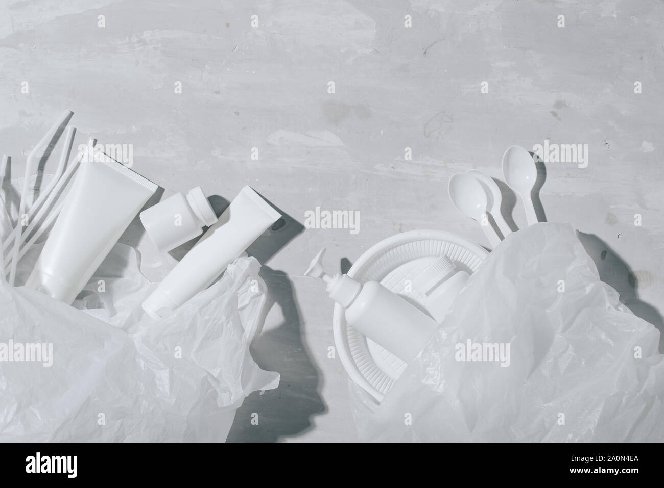 Kein Kunststoff Recycling Konzept Kunststoff weiß Geschirr Teller Tassen auf Stein Löffel. Kopieren Sie Platz. Ansicht von oben Stockfoto