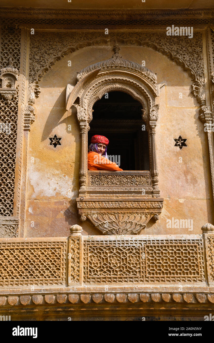 JAISALMER, Rajasthan, Indien, November 2018 Tourist in traditionellen Rajasthani Turban in geschnitzten Fenster des Kothari Patwon ki Haveli Stockfoto
