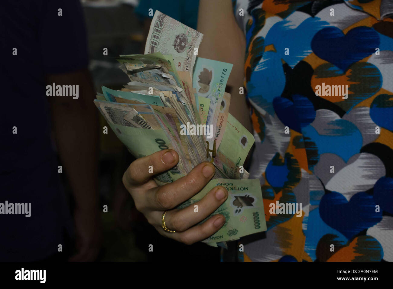 Juli 18, 2019 - HO CHI MINH VIETNAM: Frau mit einem Bündel von Vietnamesischer Dong Rechnungen. Vietnamesische Dong ist das Geld in Vietnam verwendet. Stockfoto