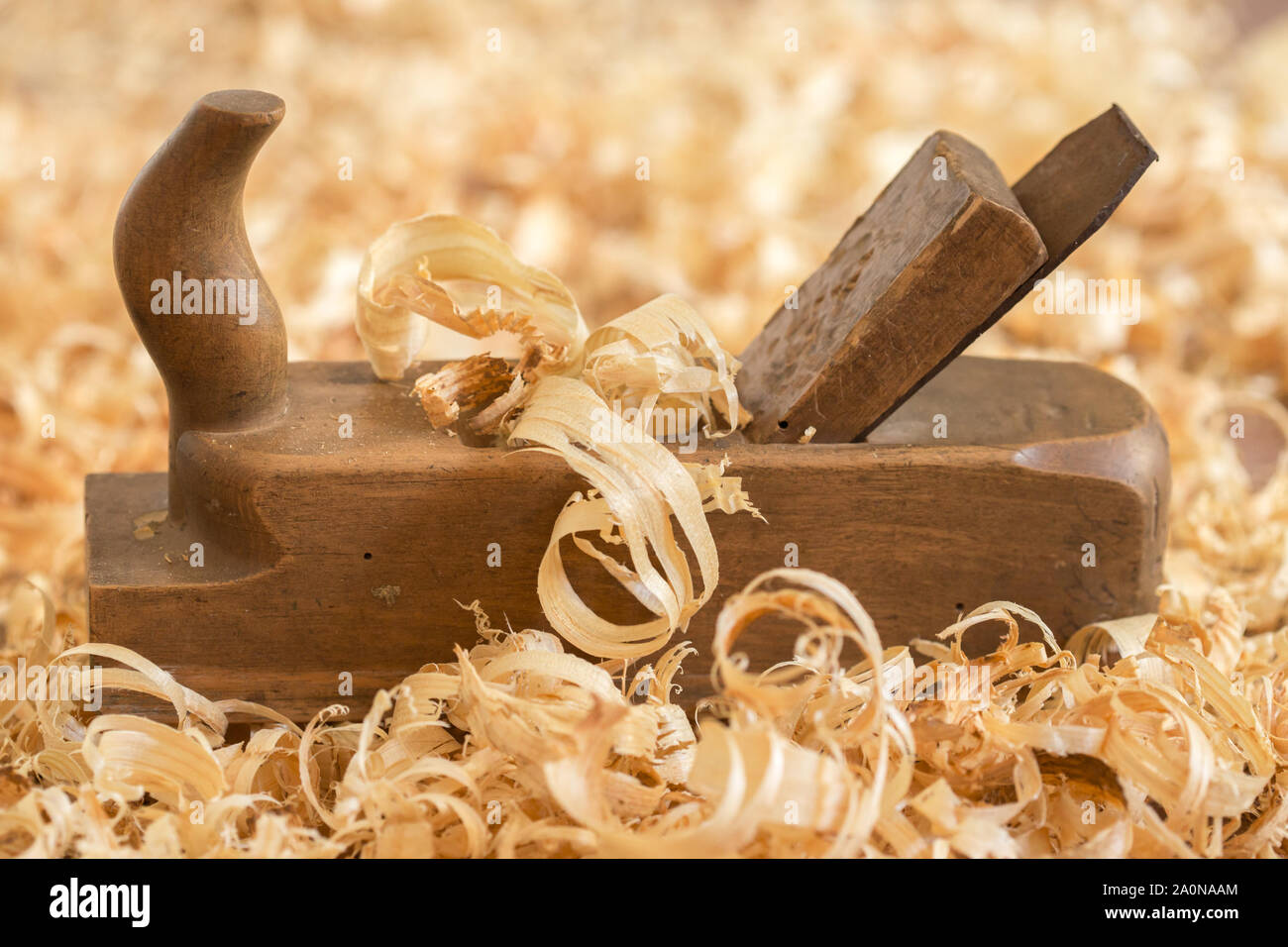 Alte hölzerne Hand Ebene für die Holzbearbeitung mit Holzwolle. Stockfoto