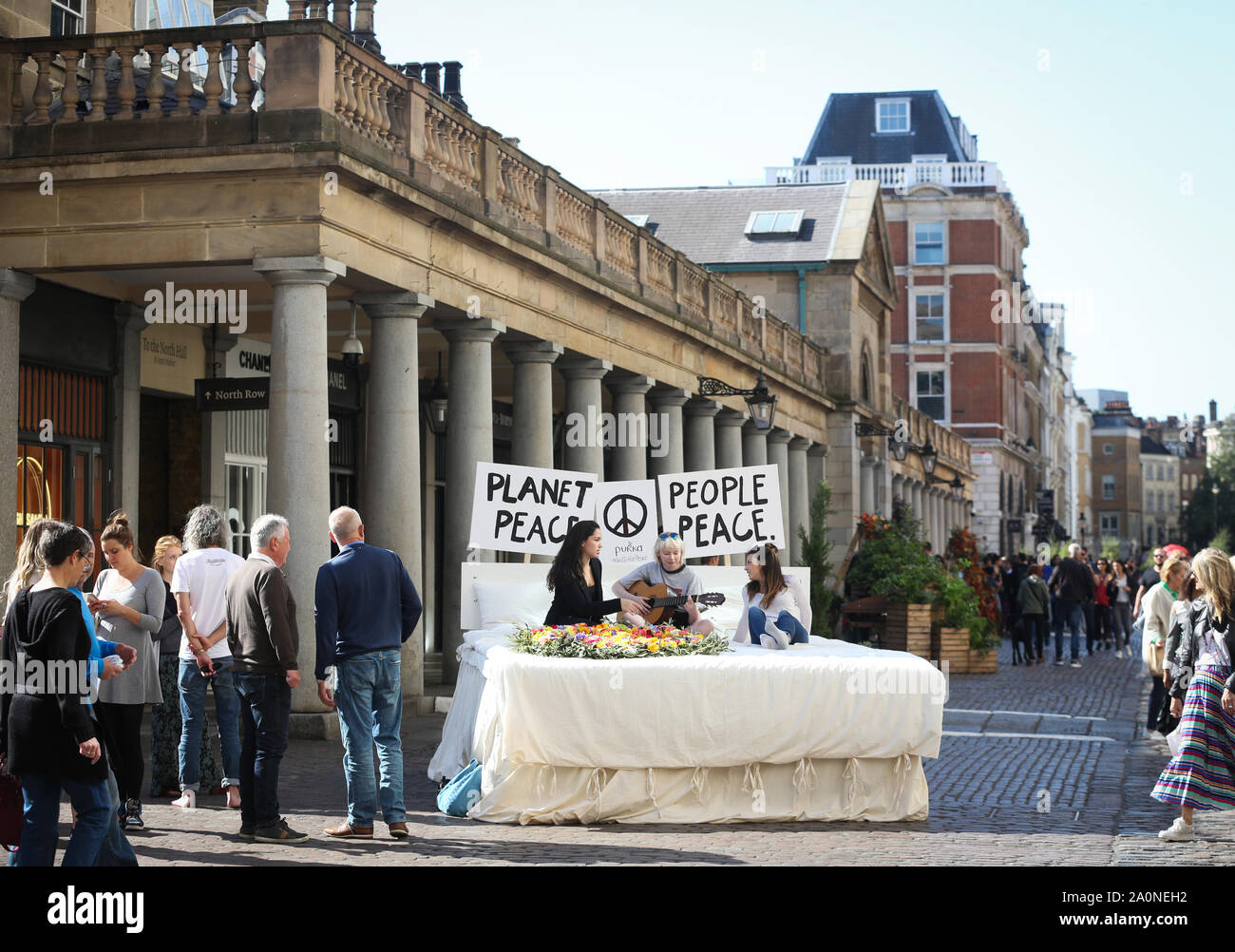 IM FOTO - L-R - Maria Maluenda, Ivy Mae und Emily Walburton Adams aus London REDAKTIONELLE VERWENDUNG NUR Mitglieder der Öffentlichkeit schreiben ihr eigenes Ôpeace Versprechen an den Planeten' auf ein ikonisches Bett, das von Ethical Herbal Tea Company in Covent Garden in London installiert wurde, Pukka Kräuter, um das friedliche Leben auf dem Planeten zu fördern und diesen Internationalen Tag des Friedens zu schützen. Stockfoto